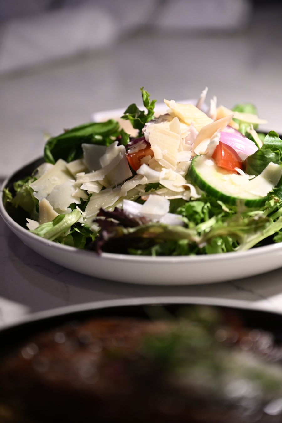 Salada de folhas verdes com lascas de parmesão e tomate